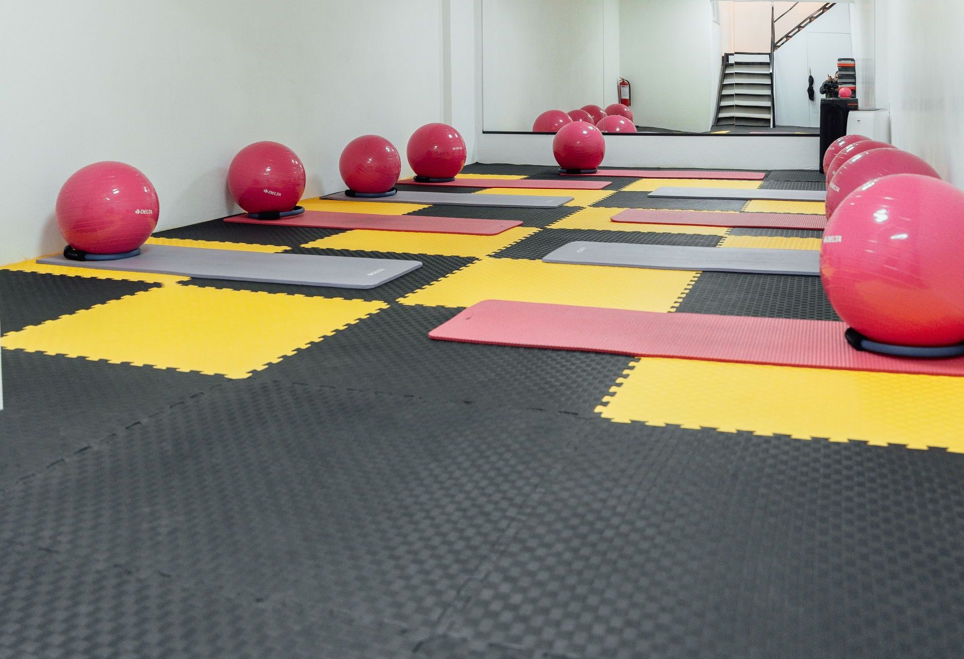 A modern, minimalist gym in Türkiye featuring yoga mats and colorful exercise balls for fitness activities.